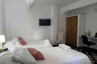 a room with two beds and a desk with a computer at Céntrico y confortable apto Casa Doña Yola 4 in Cartagena de Indias