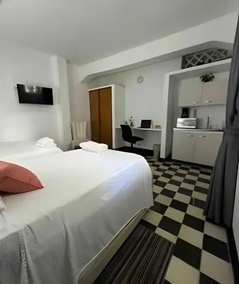 a hotel room with a large bed and a desk at Céntrico y confortable apto Casa Doña Yola 4 in Cartagena de Indias