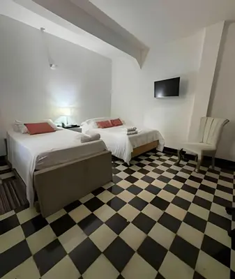 a bedroom with two beds and a checkered floor at Céntrico y confortable apto Casa Doña Yola 4 in Cartagena de Indias
