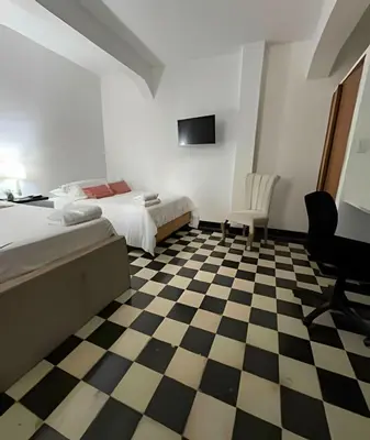 a bedroom with two beds and a checkered floor at Céntrico y confortable apto Casa Doña Yola 4 in Cartagena de Indias