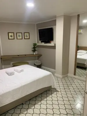 a bedroom with a bed and a flat screen tv at Apartahotel Edificio Baquero x5 Apto 301 in Barranquilla