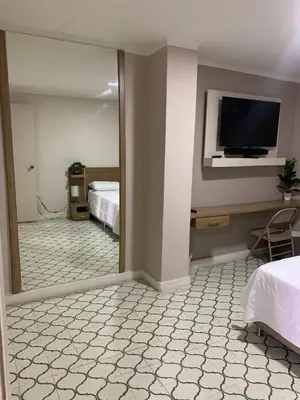 a bedroom with a mirror and a tv on the wall at Apartahotel Edificio Baquero x5 Apto 301 in Barranquilla