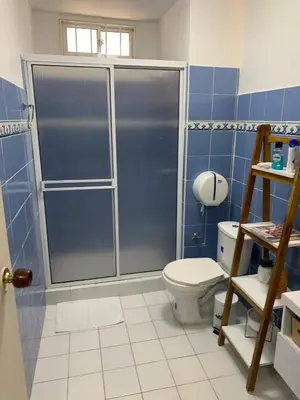 a blue tiled bathroom with a toilet and a shower at Apartahotel Edificio Baquero x5 Apto 301 in Barranquilla