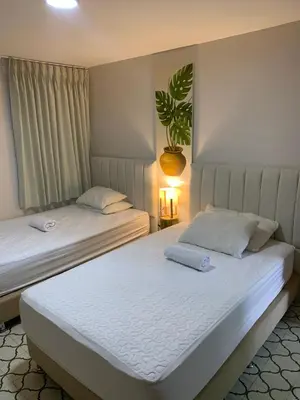 two beds in a bedroom with a plant on the wall at Apartahotel Edificio Baquero x5 Apto 201 in Barranquilla