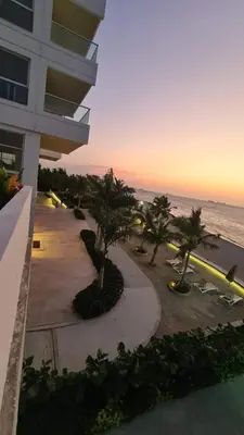a view of a building with palm trees and the ocean at exclusivo apartamento con doble vista al mar en santa marta # in Santa Marta
