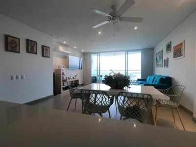 a dining room and living room with a table and chairs at exclusivo apartamento con doble vista al mar en santa marta # in Santa Marta