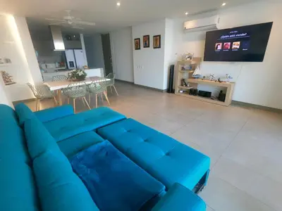 a living room with a blue couch and a table at exclusivo apartamento con doble vista al mar en santa marta # in Santa Marta