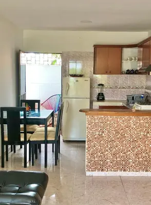 a kitchen with a table and a white refrigerator at Acogedor apartamento en bruselas in Cartagena de Indias