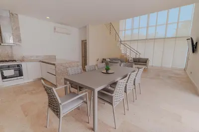 a kitchen and dining room with a table and chairs at Exclusiva casa en Baru con piscina y playa privada in Playa Blanca