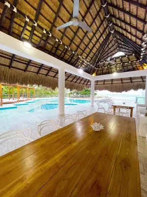 a dining room with a wooden table and a swimming pool at Exclusiva casa en Baru con piscina y playa privada in Playa Blanca