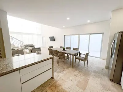 a kitchen and living room with a table and chairs at Exclusiva casa en Baru con piscina y playa privada in Playa Blanca