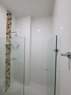 a glass shower in a white bathroom with at Yellow beach & rest in Coveñas