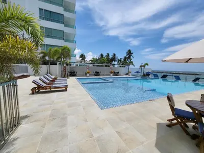 a swimming pool with lounge chairs and a building at Yellow beach & rest in Coveñas