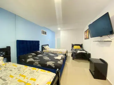 a room with two beds and a flat screen tv at HOTEL SANTA MONICA in Barranquilla