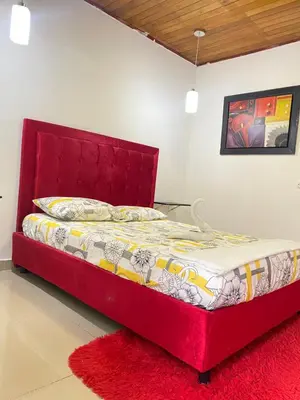 a bed with a red headboard in a bedroom at HOTEL SANTA MONICA in Barranquilla