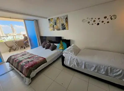 a hotel room with two beds and a balcony at Estudio Vista Laguna y Mar Piso 14 in Cartagena de Indias