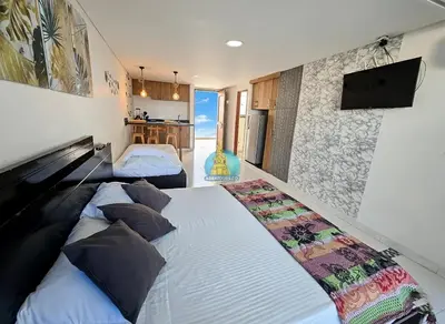 a bedroom with two beds and a tv on the wall at Estudio Vista Laguna y Mar Piso 14 in Cartagena de Indias