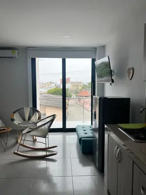 a kitchen with a chair and a couch and a window at Edificio Buenos Aires apartamento 304 moderno Sincelejo in Sincelejo