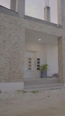 a building with a white door and a potted plant at Los Cayos Cabañas in Coveñas