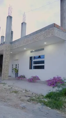 a white house with purple flowers in front of it at Los Cayos Cabañas in Coveñas