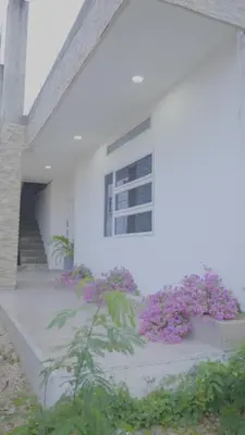 a white building with purple flowers in front of it at Los Cayos Cabañas in Coveñas