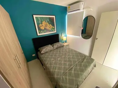 a small bedroom with a bed and a blue wall at Nice apartment close to the Marbella beach in Cartagena de Indias
