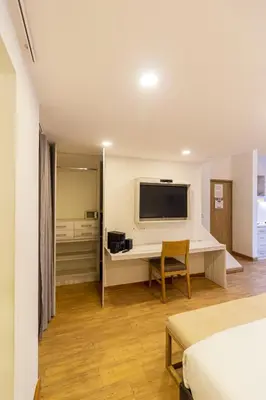 a bedroom with a bed and a television on a wall at Cartagena Suites de Manga in Cartagena de Indias