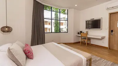 a hotel room with a bed and a television at Cartagena Suites de Manga in Cartagena de Indias
