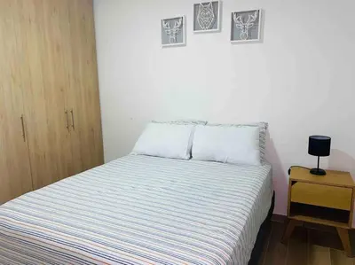a small bedroom with a bed and a night stand at REFUGIO URBANO - Apartamento para descanso y trabajo remoto en Alameda del Río Barranquilla in Barranquilla