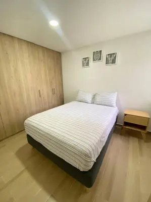a bedroom with a bed with striped sheets on it at REFUGIO URBANO - Apartamento para descanso y trabajo remoto en Alameda del Río Barranquilla in Barranquilla