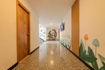 a hallway with a wooden door and a hallway with stairs at Hostel Dorado Plaza Getsemaní in Cartagena de Indias