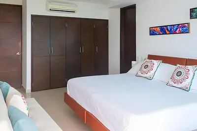a bedroom with a large white bed and brown cabinets at 2 dormitorios Morros. Vista Panorámica y salida Playa in Cartagena de Indias