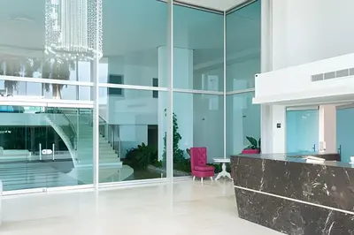 an office with glass walls and a pink chair at 2 dormitorios Morros. Vista Panorámica y salida Playa in Cartagena de Indias