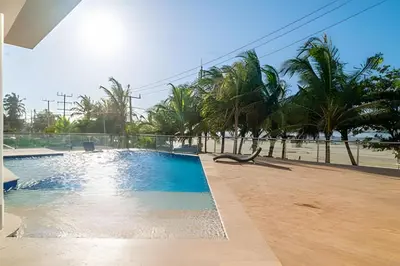 a swimming pool next to a beach with palm trees at 2 dormitorios Morros. Vista Panorámica y salida Playa in Cartagena de Indias