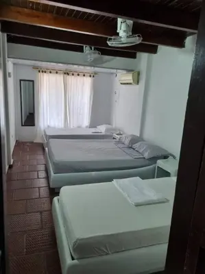 a room with three beds in a room at Cabaña Lilimar. in La Perdiz