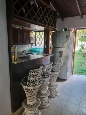 a kitchen with four chairs and a refrigerator at Cabaña Lilimar. in La Perdiz