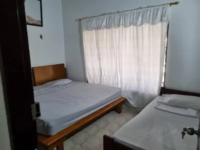 two beds in a room with a window at Cabaña Lilimar. in La Perdiz