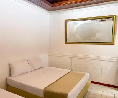 a bed in a room with a picture on the wall at Hotel Barranquilla Prado in Barranquilla