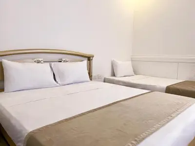 two beds in a hotel room with white walls at Hotel Barranquilla Prado in Barranquilla