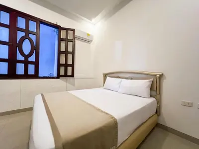 a bed in a room with a window at Hotel Barranquilla Prado in Barranquilla