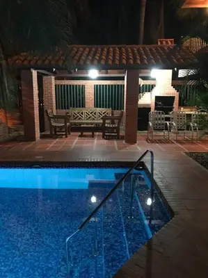 a swimming pool at night with a table and a bench at Casa de playa Nijegi en Santa Veronica in Juan de Acosta