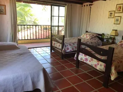 a bedroom with two beds and a balcony at Casa de playa Nijegi en Santa Veronica in Juan de Acosta