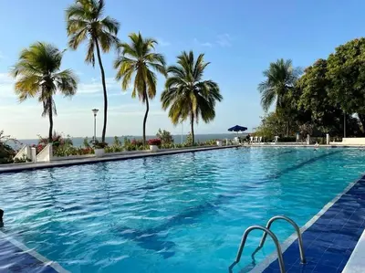 a large swimming pool with palm trees in the background at Perla Santa - Luxury Condo in Santa Marta