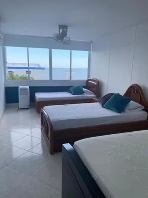 a room with three beds and a window at Perla Santa - Luxury Condo in Santa Marta