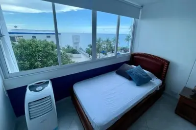 a bedroom with a bed and a large window at Perla Santa - Luxury Condo in Santa Marta
