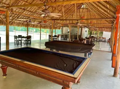 a pool table sitting inside of a pavilion with a table at Perla Santa - Luxury Condo in Santa Marta