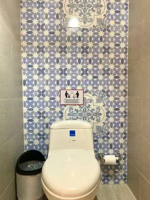 a toilet in a bathroom with blue and white tiles at Gorgeous 8 BR House w/ Pool in the Old City in Cartagena de Indias