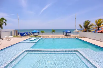 a large swimming pool with the beach in the background at Magico Apartamento Frente al Mar 3 Habitaciones PV81 in Coveñas
