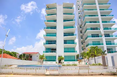 a tall white building with a pool in front of it at Magico Apartamento Frente al Mar 3 Habitaciones PV81 in Coveñas