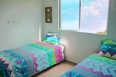 a bedroom with two beds and a window at Magico Apartamento Frente al Mar 3 Habitaciones PV81 in Coveñas